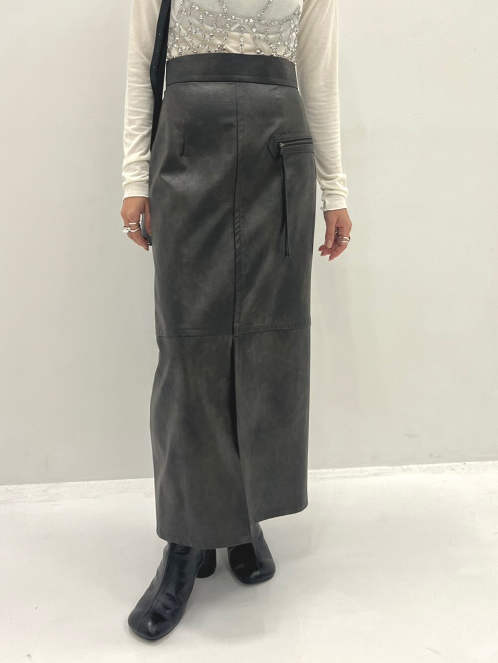 ブラック系のブーツ、シルバー系のベスト、ホワイト系のTシャツ/カットソーを着用したレディースの秋コーディネートの4枚目の写真