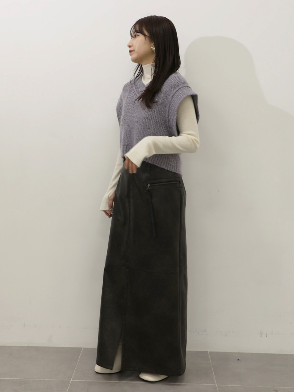 ホワイト系のニット/セーター、パープル系のベスト、グレー系のスカートを着用したレディースの秋コーディネートの2枚目の写真