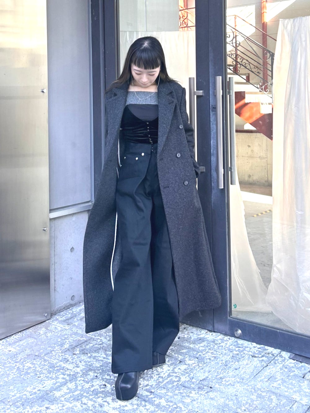 グレー系のチェスターコートを着用したレディースの秋コーディネートの3枚目の写真