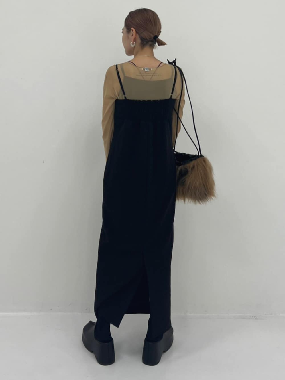 ベージュ系のTシャツ/カットソー、ブラック系のスリッポン、ブラック系のワンピースを着用したレディースの秋コーディネートの3枚目の写真