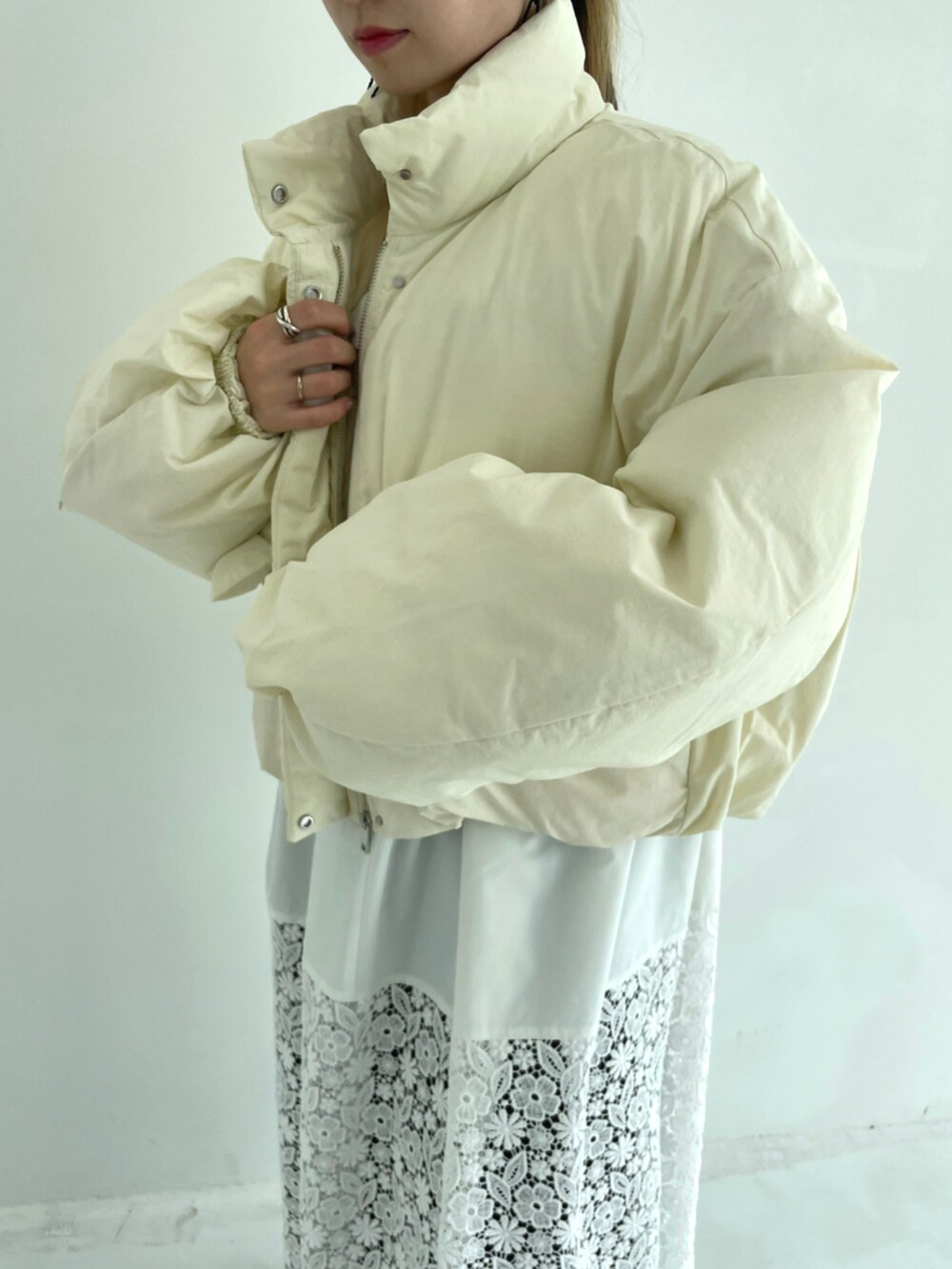 ホワイト系のワンピース、ベージュ系のダウンジャケット/コートを着用したレディースの秋コーディネートの7枚目の写真