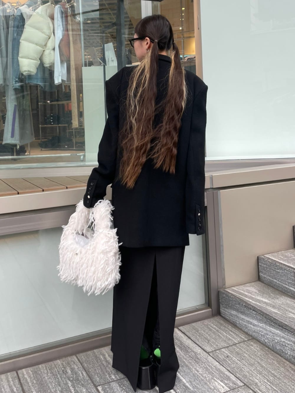 ブラック系のテーラードジャケット、ホワイト系のショルダーバッグを着用したレディースの秋コーディネートの3枚目の写真