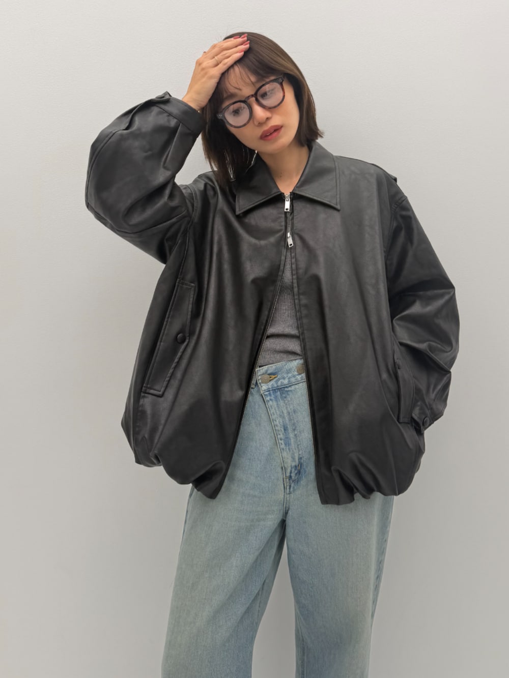 ブルー系のデニムパンツ、ブラック系のライダースジャケットを着用したレディースの秋コーディネートの2枚目の写真