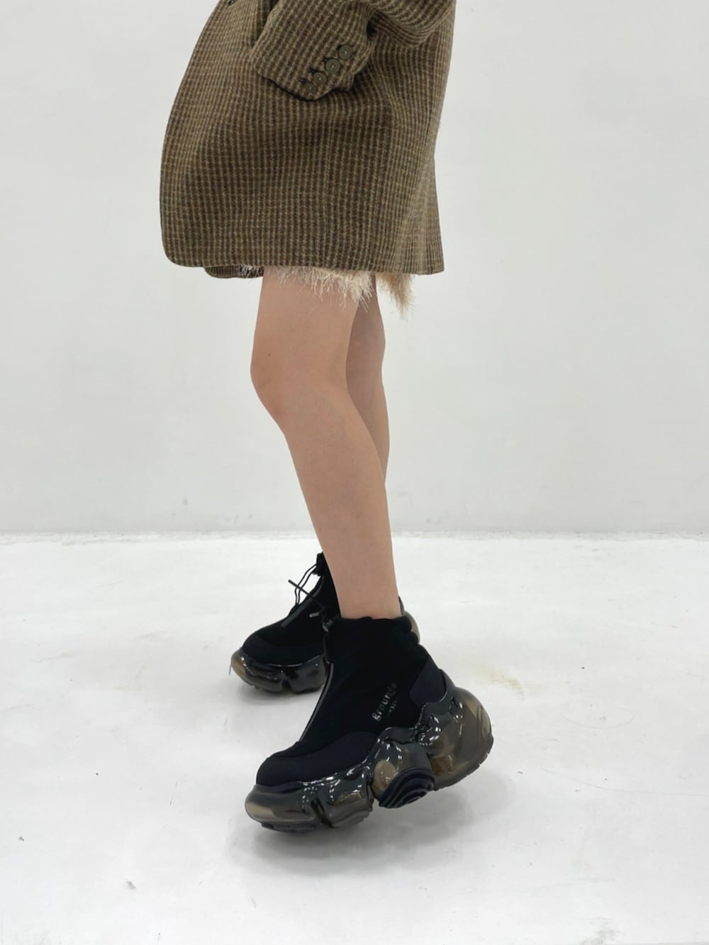 イエロー系のテーラードジャケット、ブラック系のスニーカーを着用したレディースの秋コーディネートの4枚目の写真