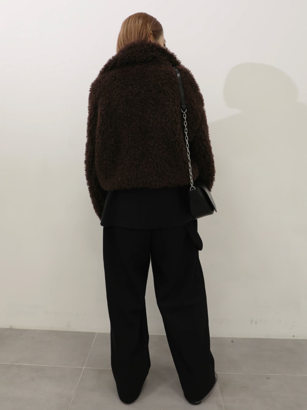 ブラック系のショルダーバッグ、ブラウン系のブルゾンを着用したレディースの秋コーディネートの3枚目の写真