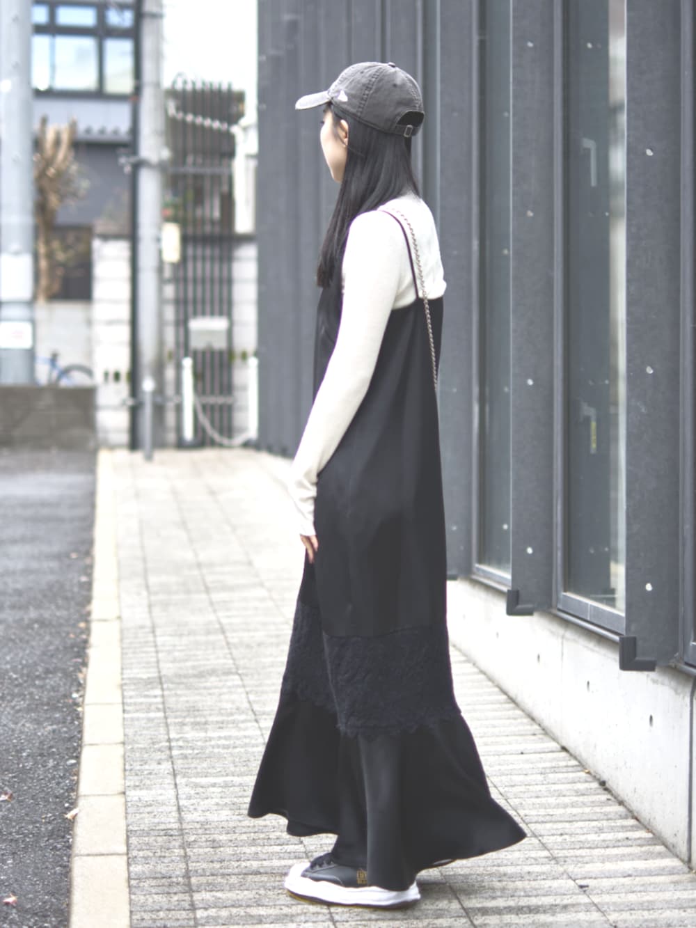 ブラック系のドレス、ピンク系のショルダーバッグ、ブラック系のキャップを着用したレディースの冬コーディネートの5枚目の写真