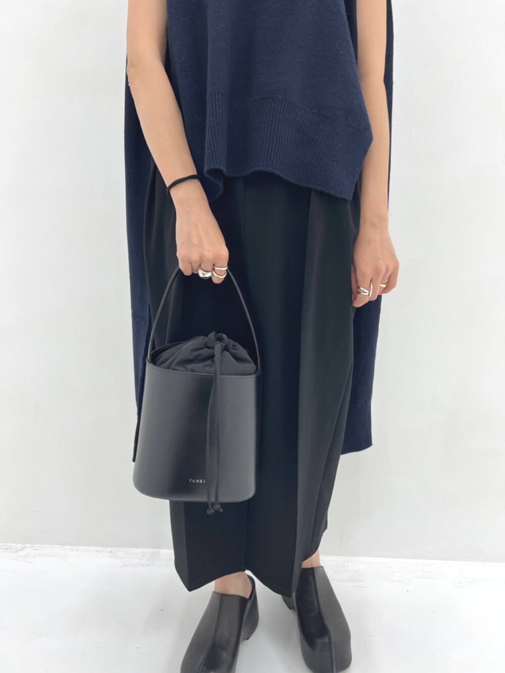 ブラック系のハンドバッグ、ブラック系のスリッポンを着用したレディースの秋コーディネートの5枚目の写真