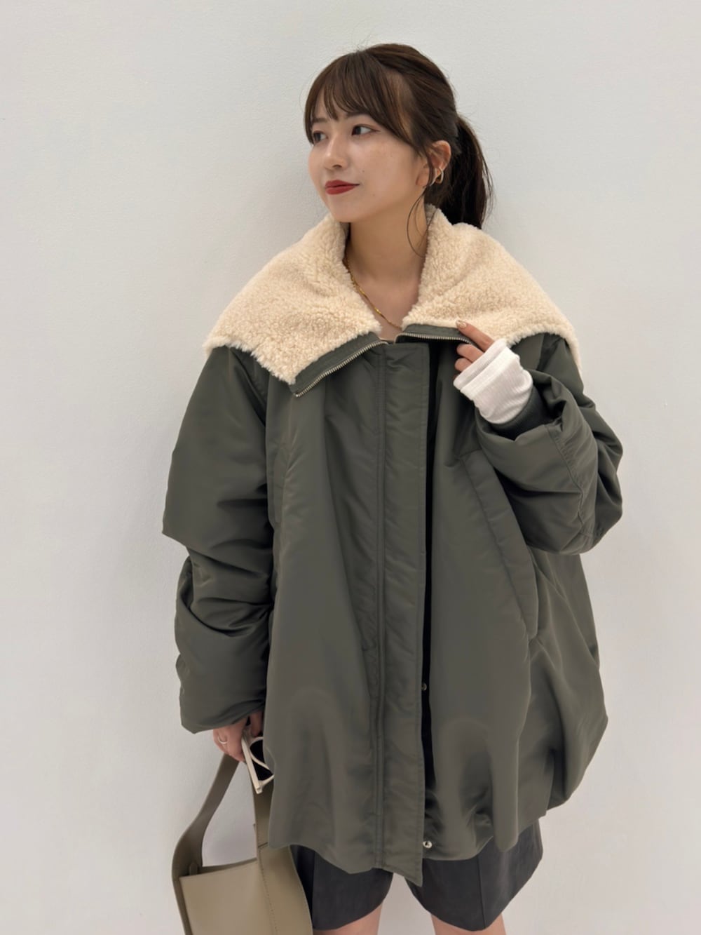 グリーン系のブルゾンを着用したレディースの秋コーディネートの3枚目の写真