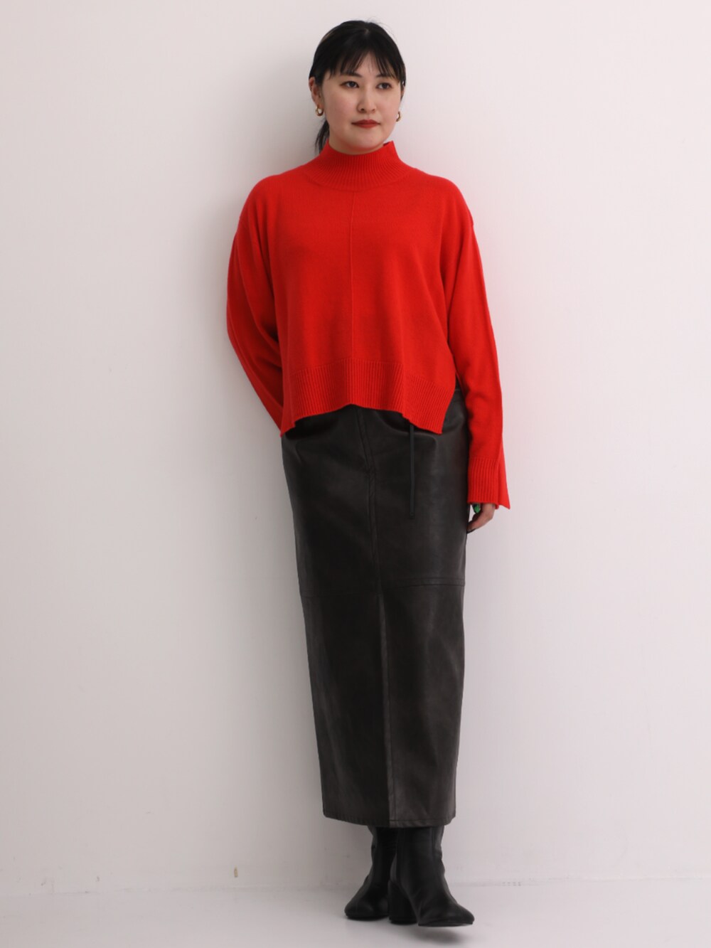 グレー系のスカート、レッド系のニット/セーターを着用したレディースの秋コーディネートの2枚目の写真