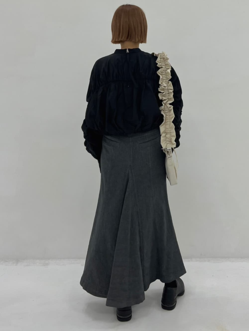 ベージュ系のショルダーバッグ、ブラック系のシャツ/ブラウス、グレー系のスカートを着用したレディースの秋コーディネートの3枚目の写真