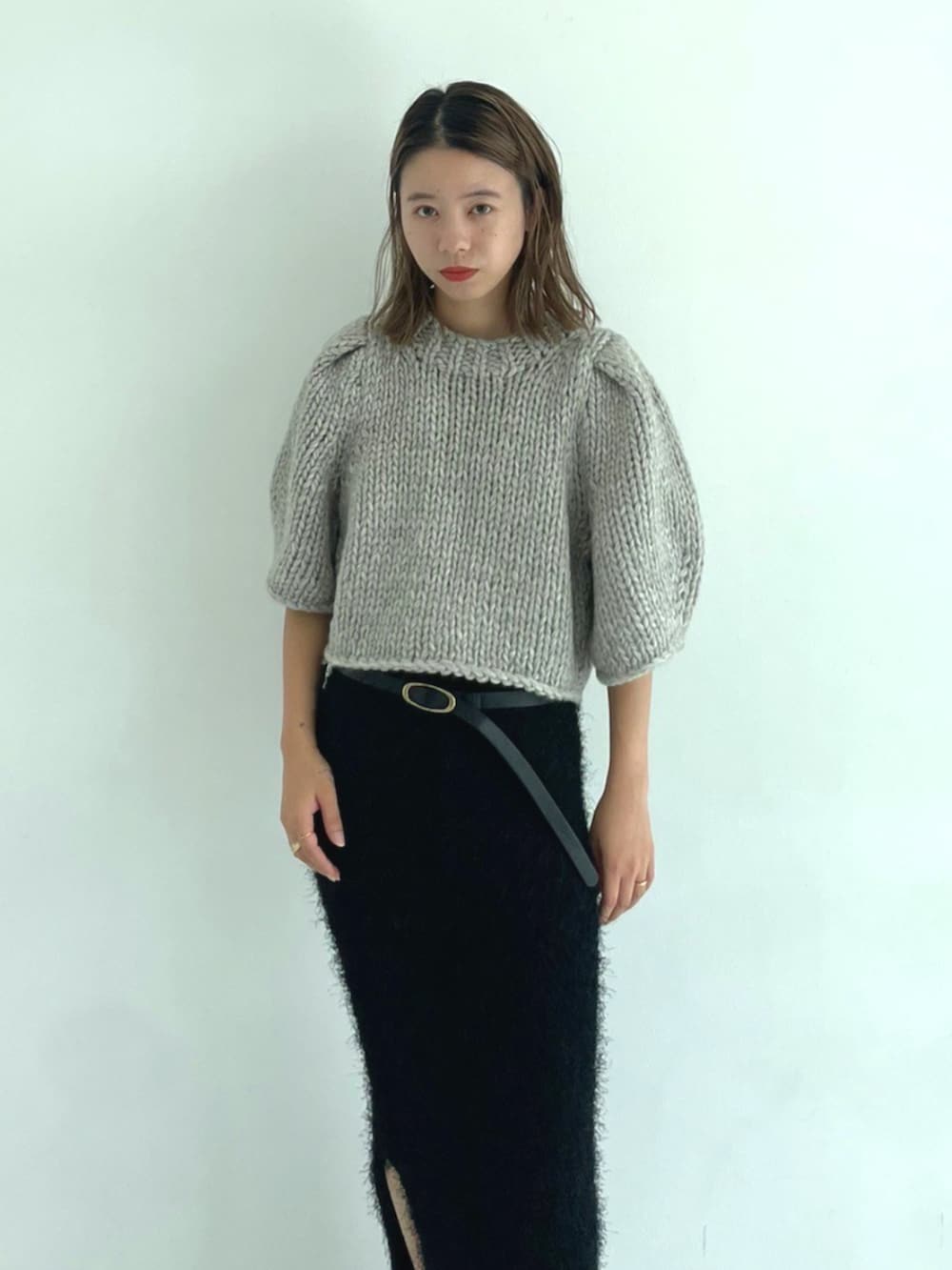 ブラック系のスカート、グレー系のニット/セーターを着用したレディースの秋コーディネートの3枚目の写真