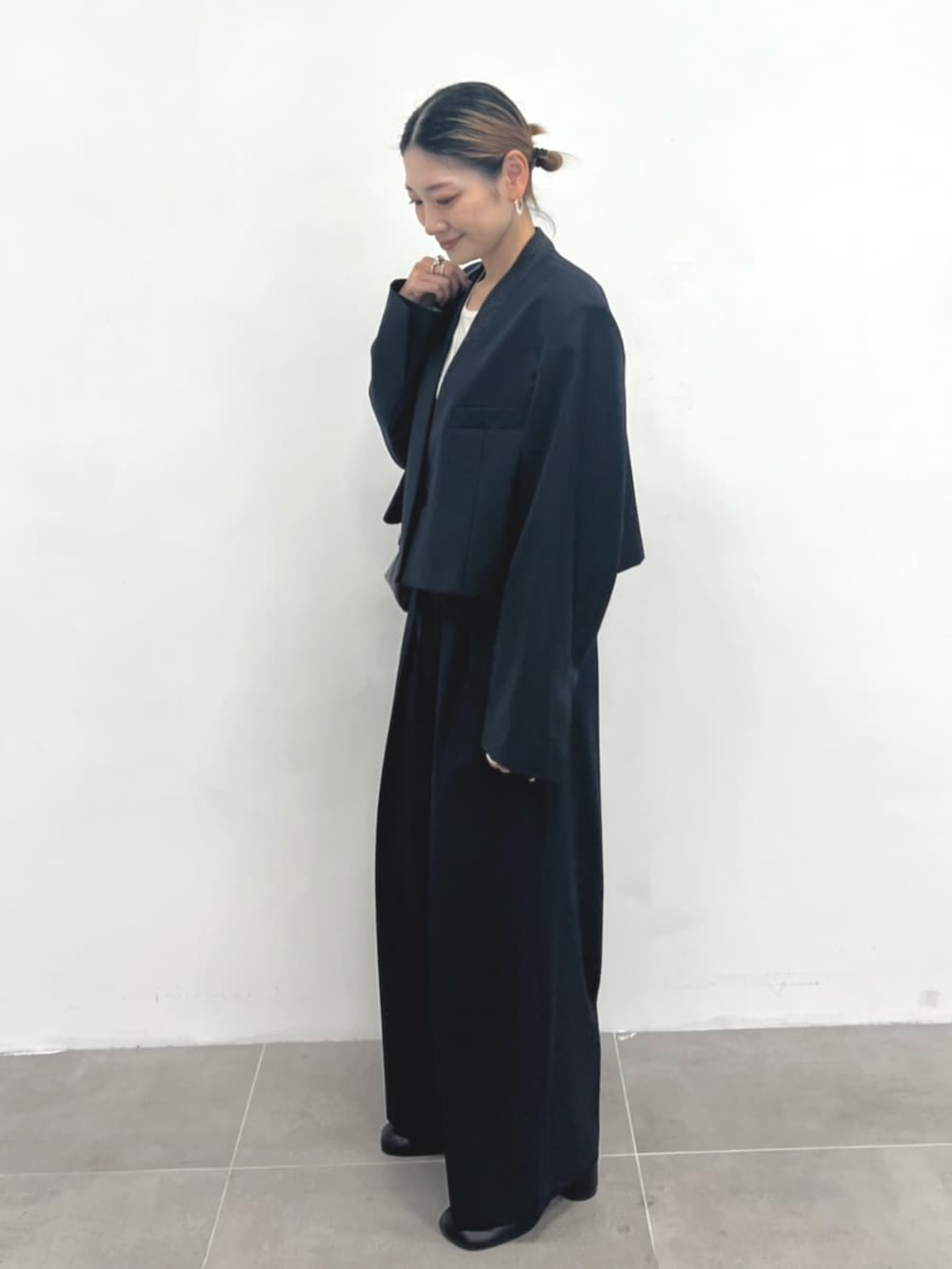 ホワイト系のTシャツ/カットソー、ブラック系のブーツ、ブルー系のその他パンツを着用したレディースの秋コーディネートの2枚目の写真