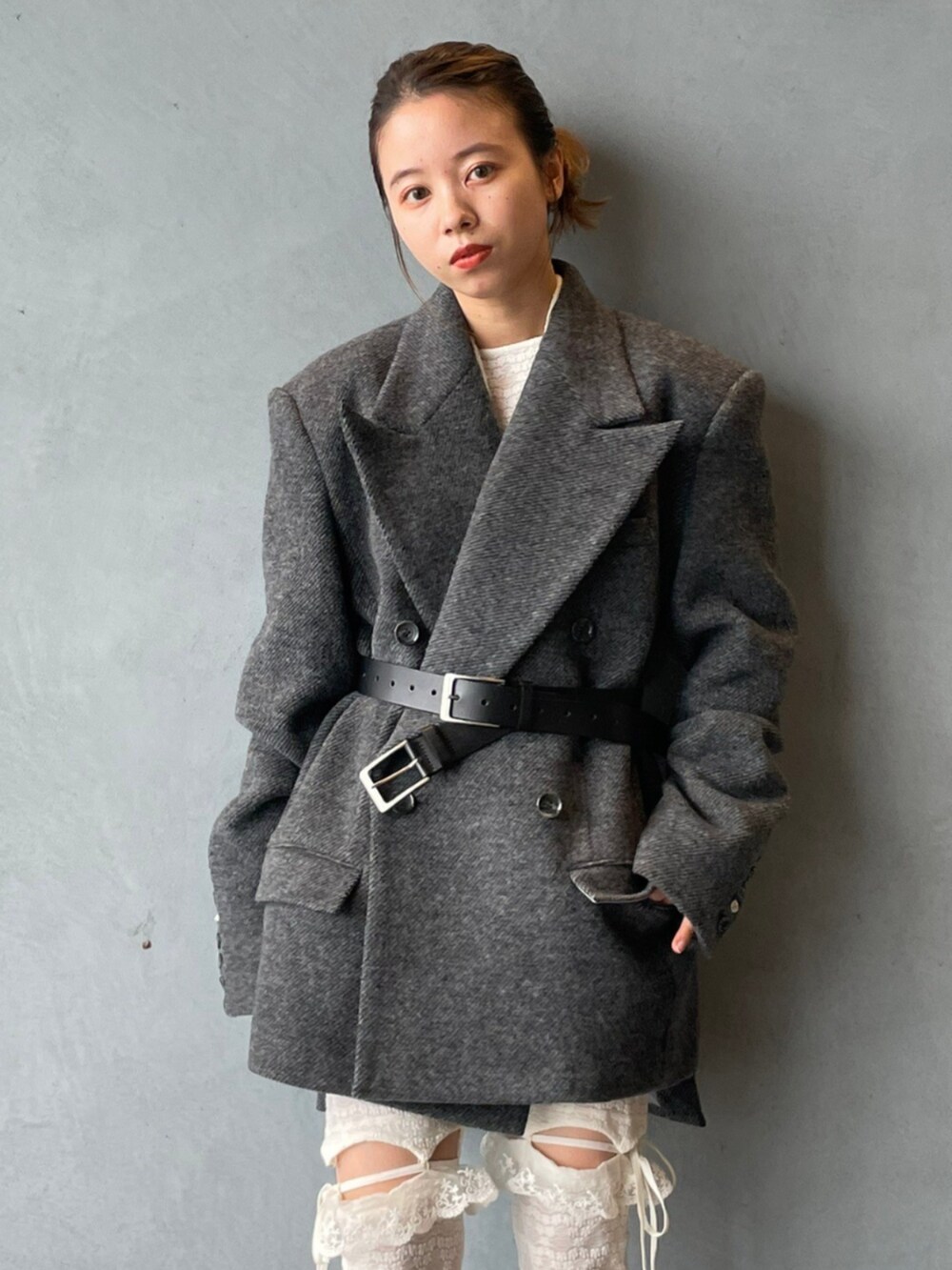 グレー系のテーラードジャケット、ブラック系のベルト、ホワイト系のタイツ/ストッキングを着用したレディースの秋コーディネートの4枚目の写真