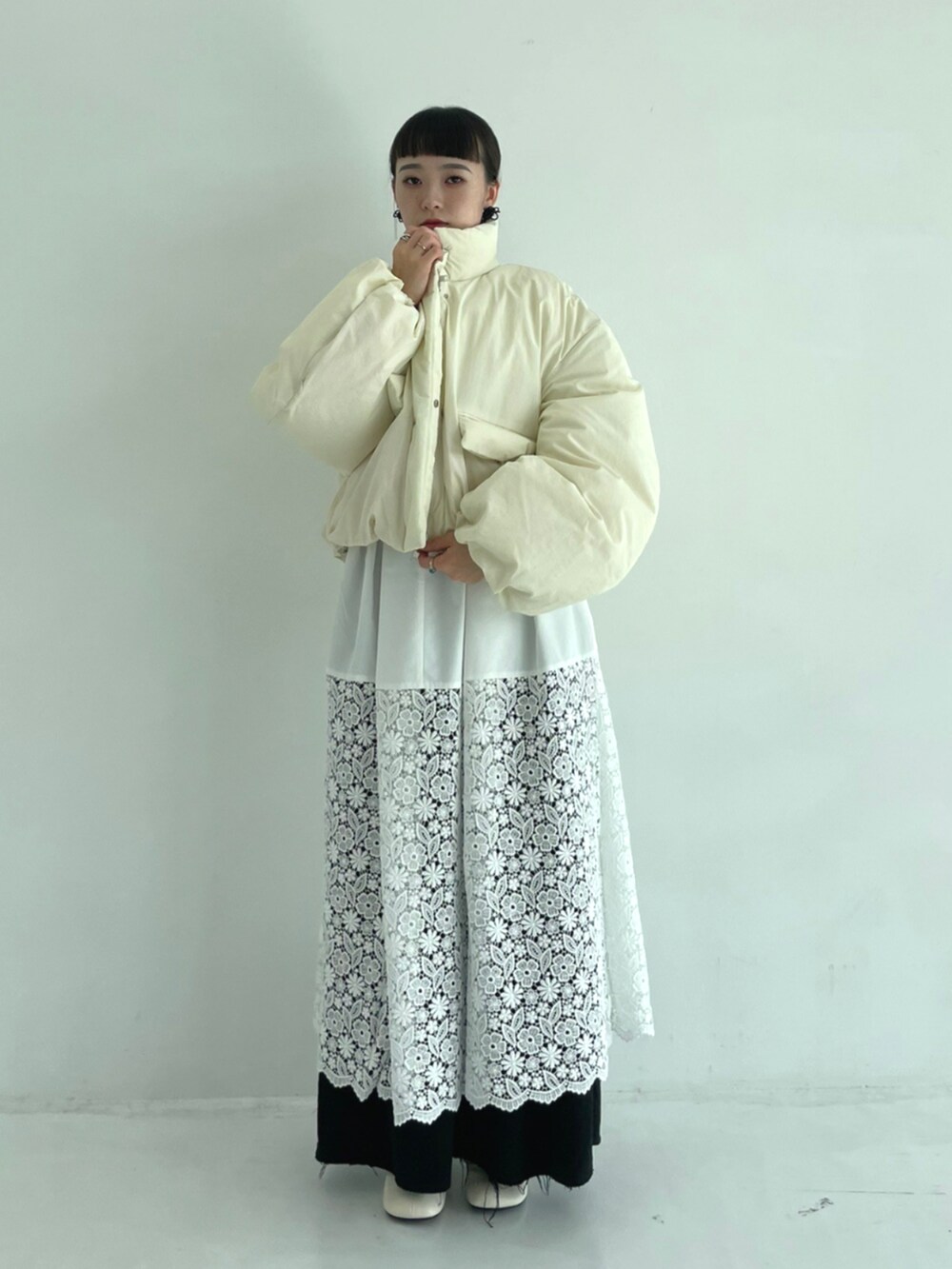 ホワイト系のワンピース、ベージュ系のダウンジャケット/コートを着用したレディースの秋コーディネートの2枚目の写真