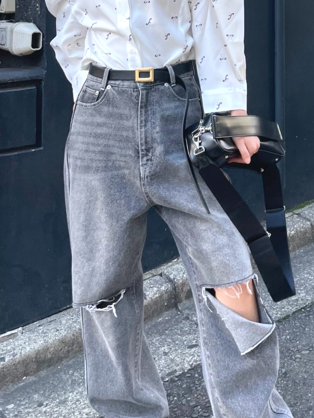 ブラック系のショルダーバッグ、ホワイト系のシャツ/ブラウス、ブルー系のデニムパンツを着用したレディースの秋コーディネートの4枚目の写真