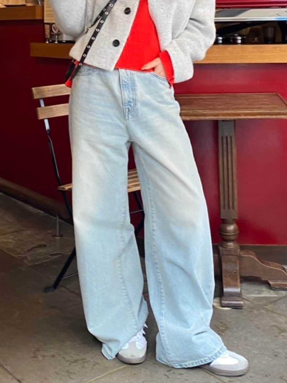 ブルー系のデニムパンツ、グレー系のその他アウター、レッド系のニット/セーターを着用したレディースの秋コーディネートの3枚目の写真