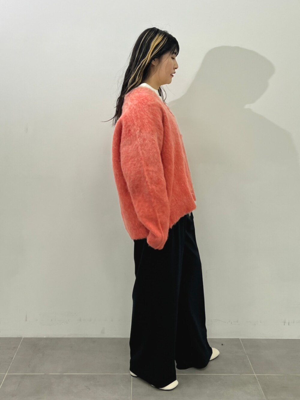 ピンク系のニット/セーター、ブラック系のスラックスを着用したレディースの秋コーディネートの2枚目の写真