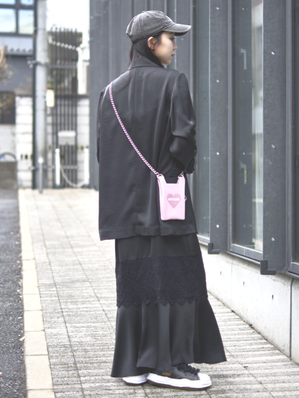 ブラック系のドレス、ピンク系のショルダーバッグ、ブラック系のキャップを着用したレディースの冬コーディネートの3枚目の写真