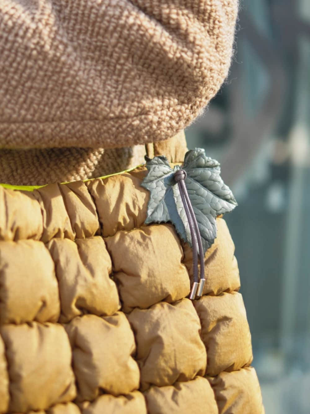 イエロー系のその他アウター、ブラウン系のショルダーバッグを着用したレディースの冬コーディネートの3枚目の写真