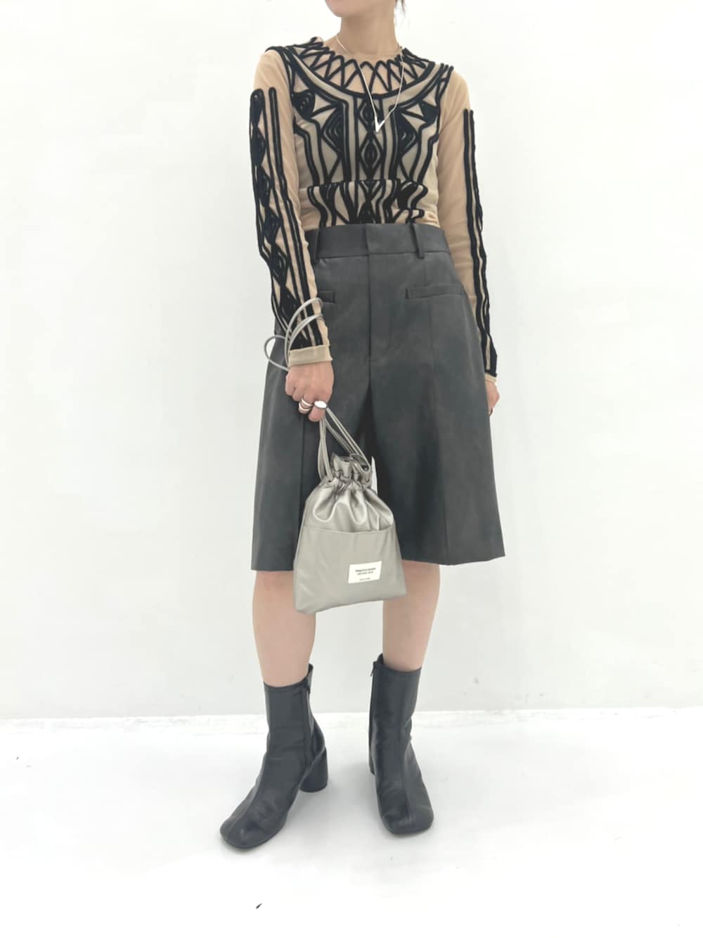 シルバー系のショルダーバッグ、ブラウン系のその他パンツ、ブラック系のブーツを着用したレディースの秋コーディネートの3枚目の写真