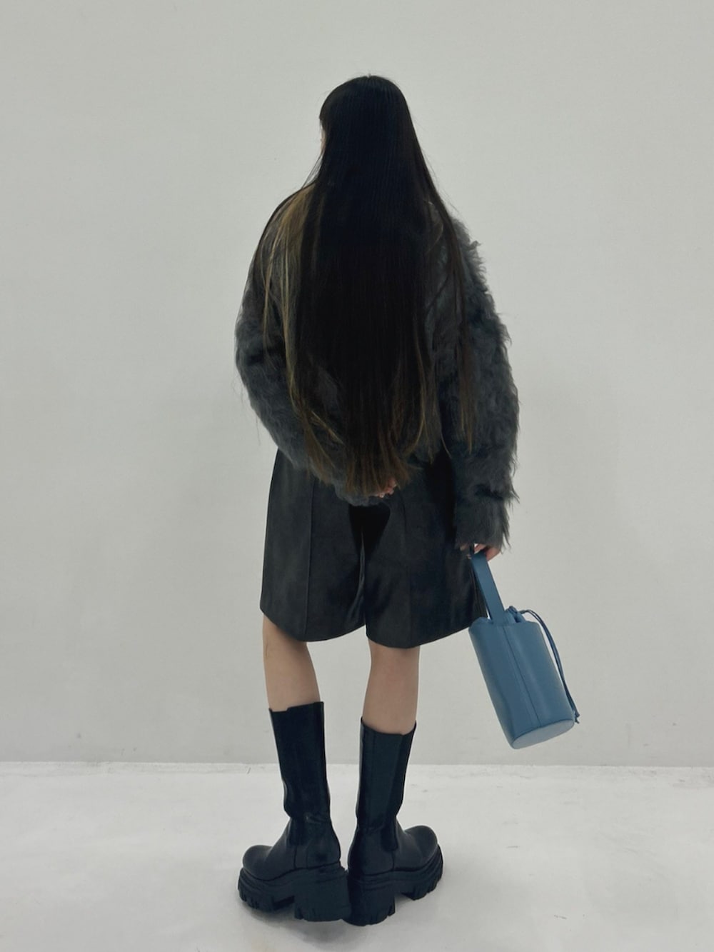 ブラック系のブーツ、ブラウン系のその他パンツ、グレー系のカーディガン/ボレロを着用したレディースの秋コーディネートの3枚目の写真