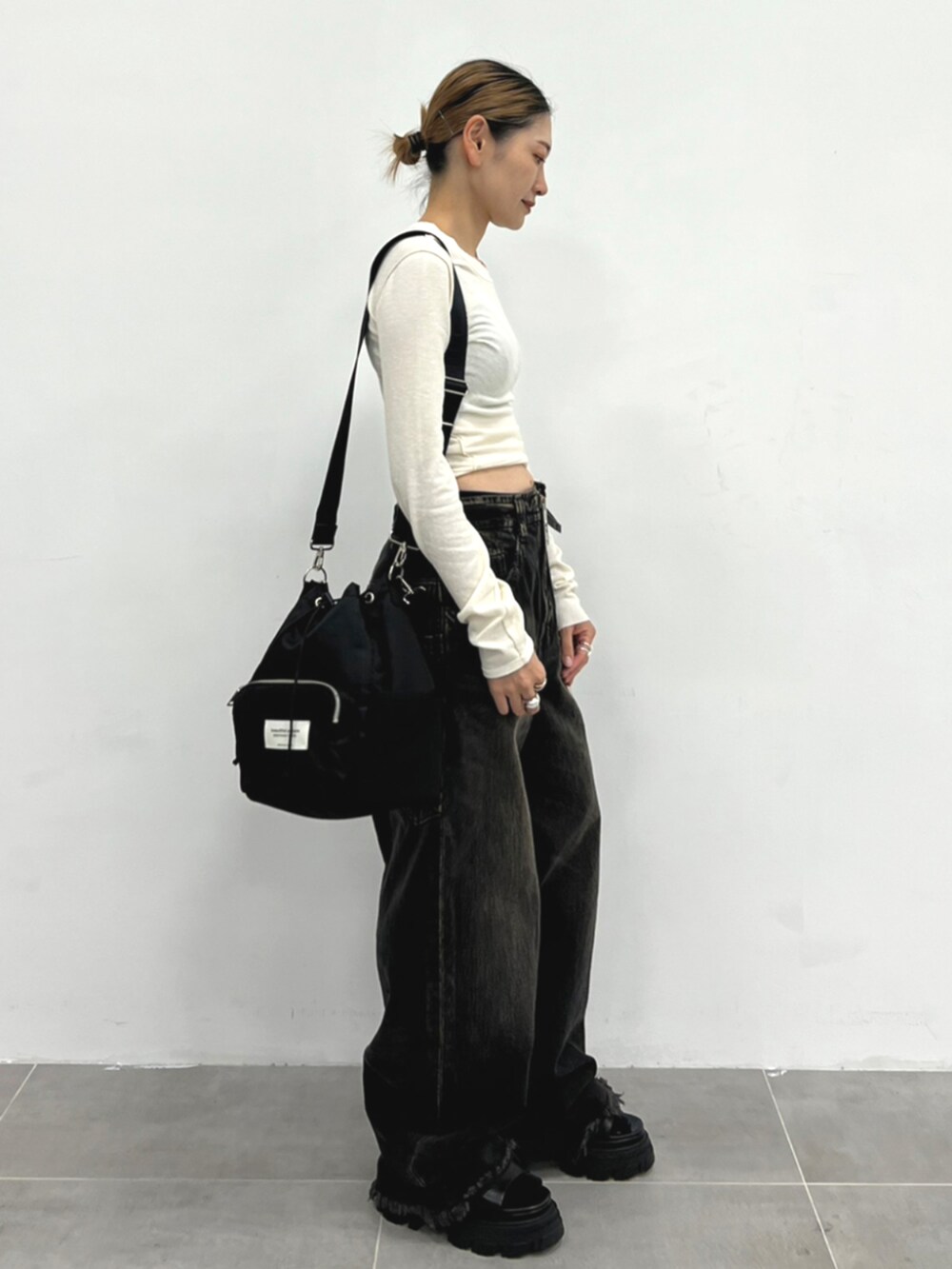 ブラック系のハンドバッグを着用したレディースの冬コーディネートの2枚目の写真