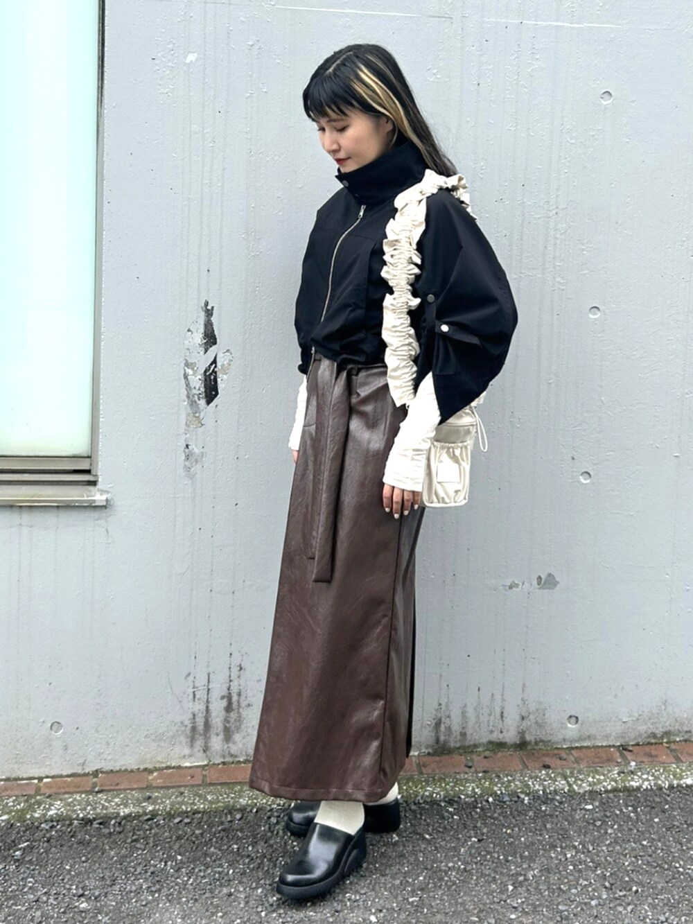 ホワイト系のTシャツ/カットソー、ブラック系のその他アウター、ブラウン系のスカートを着用したレディースの秋コーディネートの2枚目の写真