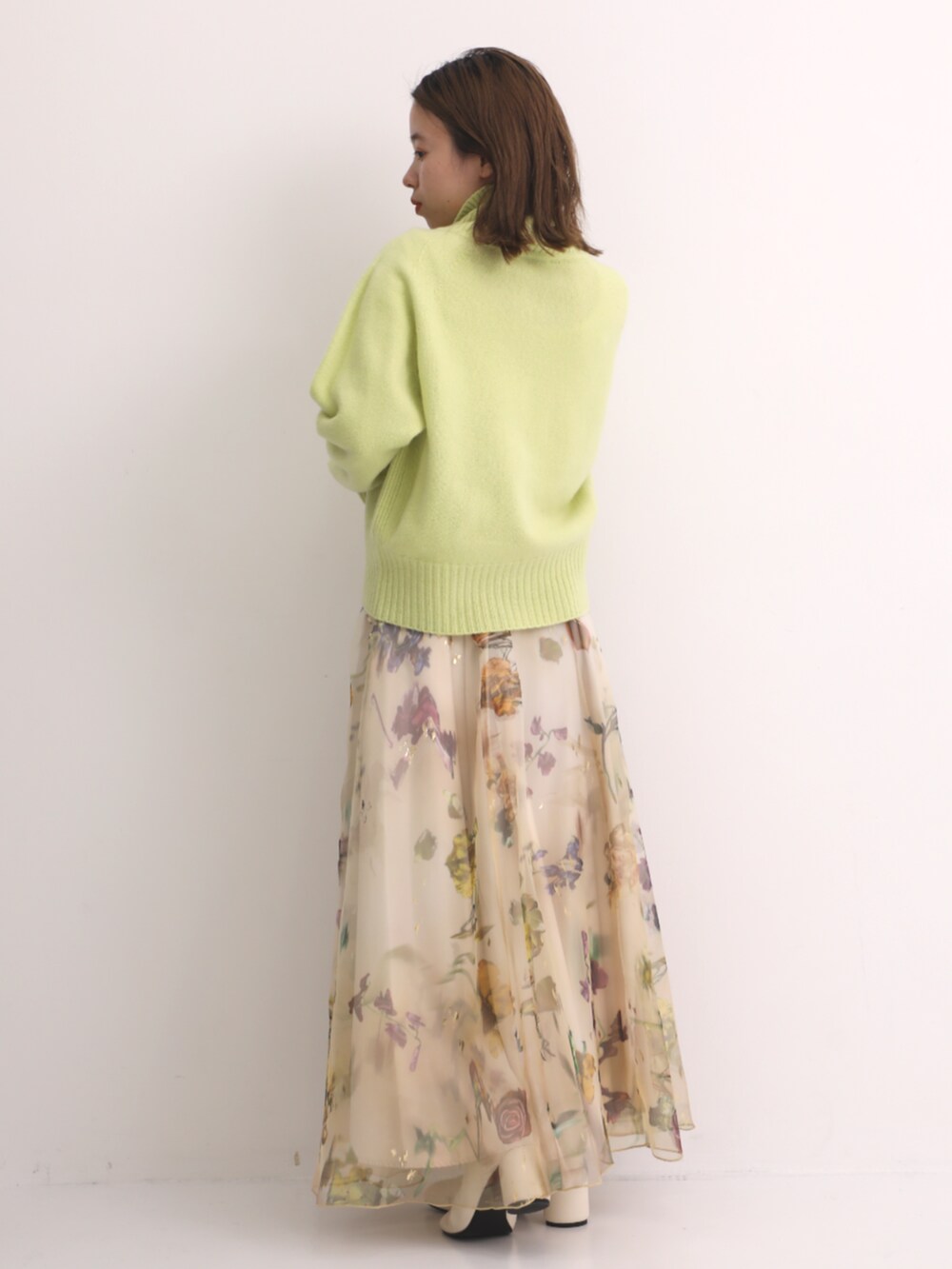 グリーン系のニット/セーターを着用したレディースの秋コーディネートの3枚目の写真