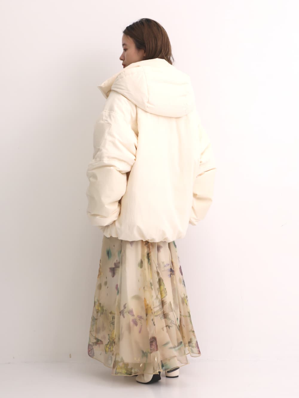 グリーン系のニット/セーター、ホワイト系のダウンジャケット/コートを着用したレディースの秋コーディネートの3枚目の写真