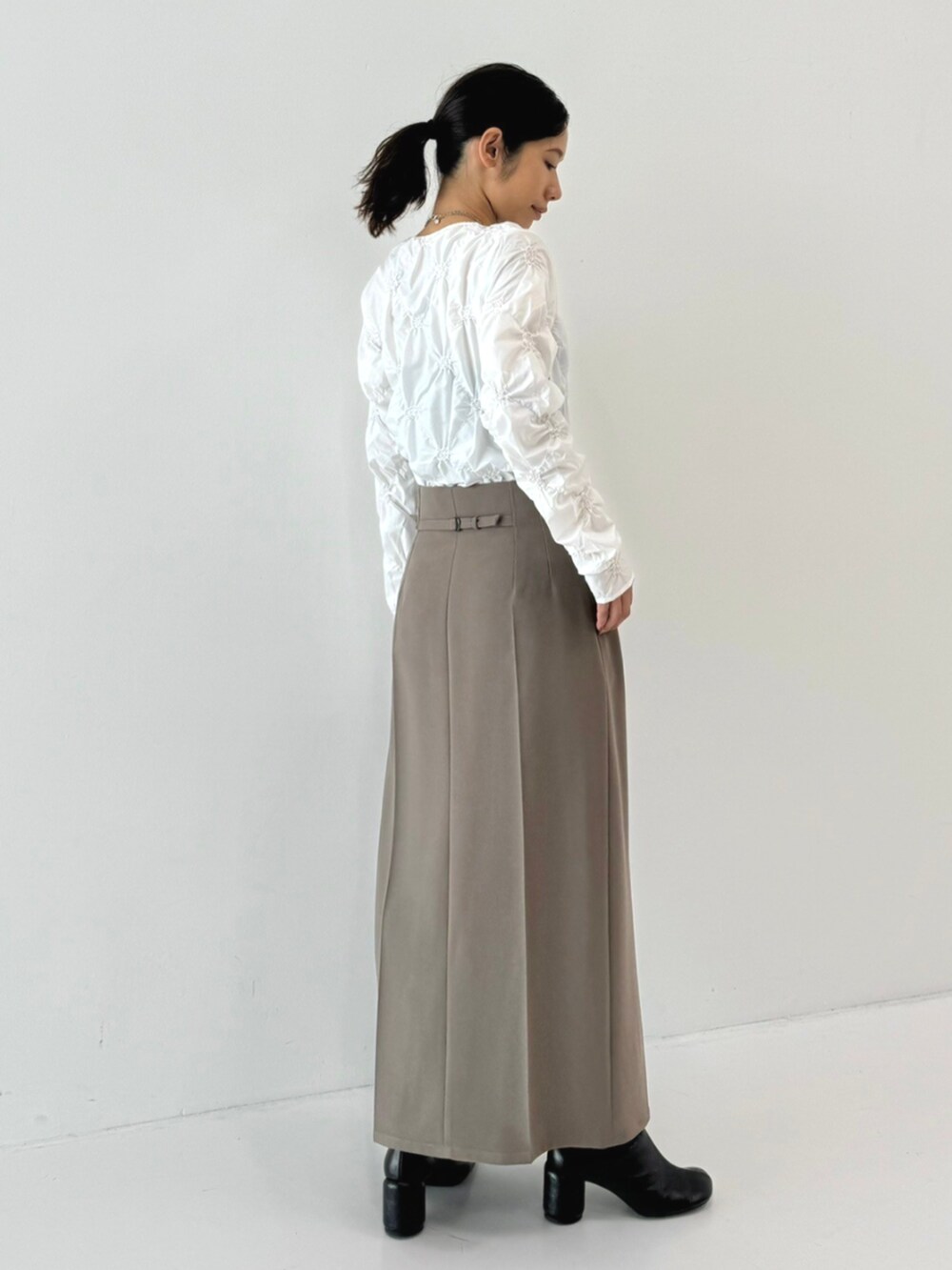 ホワイト系のTシャツ/カットソー、グレー系のスカートを着用したレディースの秋コーディネートの3枚目の写真