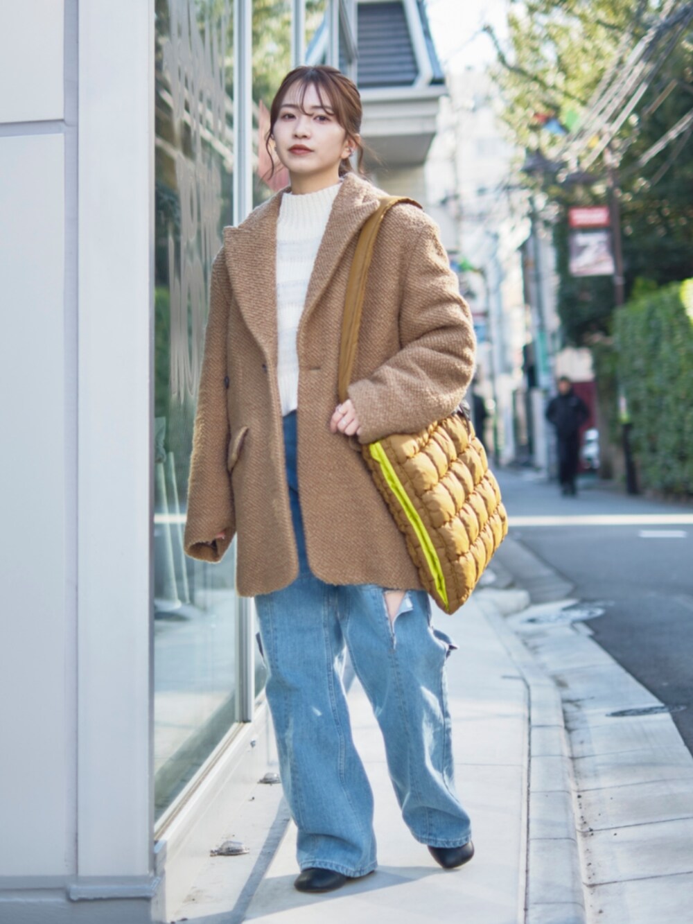 イエロー系のその他アウター、ブラウン系のショルダーバッグを着用したレディースの冬コーディネートの2枚目の写真