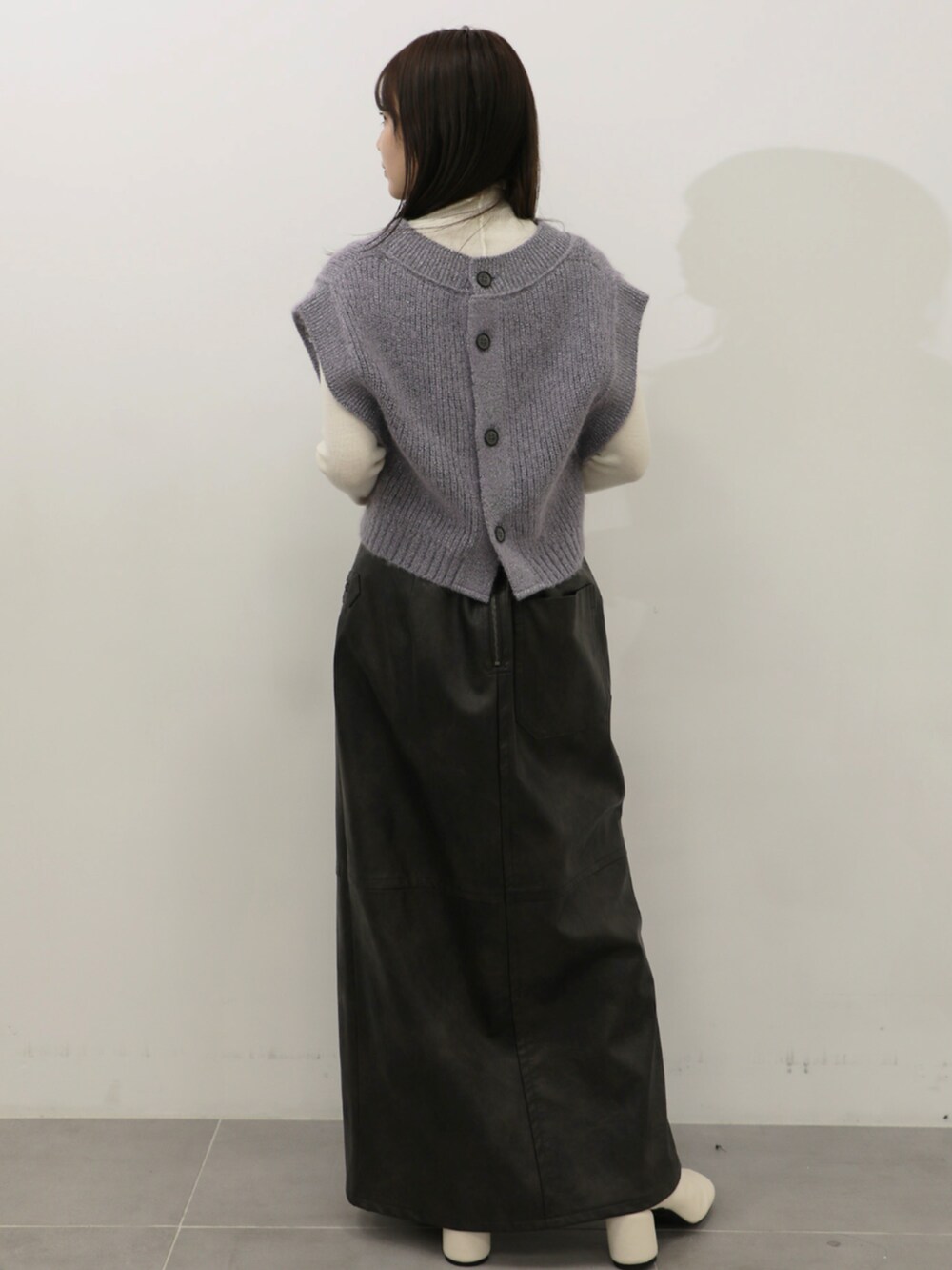 ホワイト系のニット/セーター、パープル系のベスト、グレー系のスカートを着用したレディースの秋コーディネートの3枚目の写真