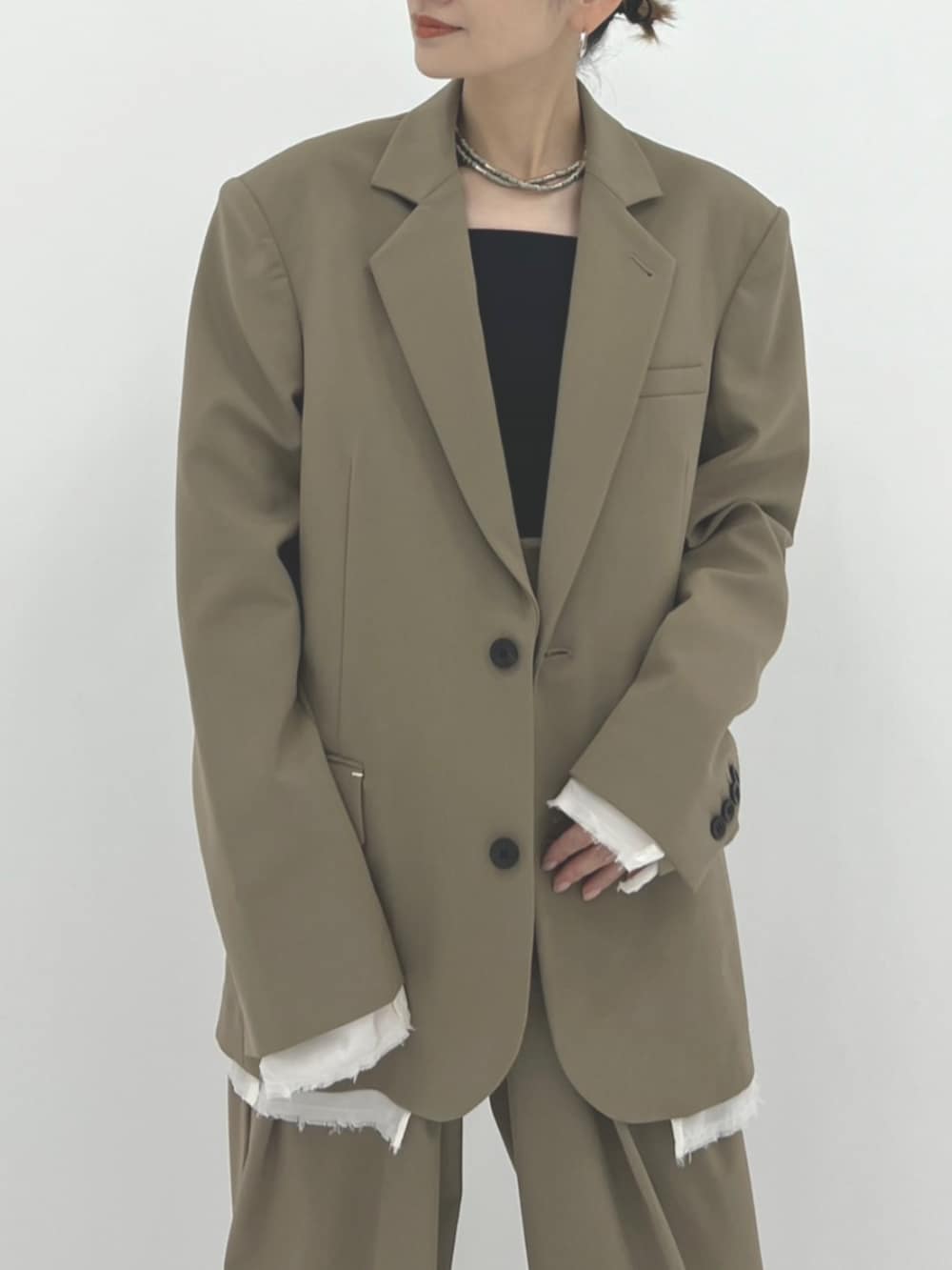 グリーン系のスラックス、グリーン系のテーラードジャケットを着用したレディースの秋コーディネートの3枚目の写真