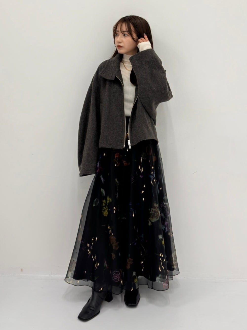 グレー系のブルゾン、ホワイト系のニット/セーターを着用したレディースの秋コーディネートの2枚目の写真