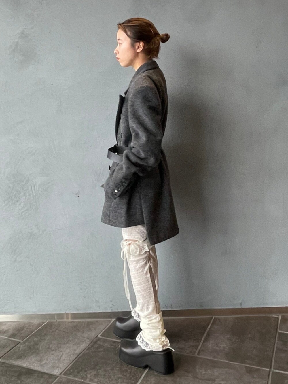 グレー系のテーラードジャケット、ブラック系のベルト、ホワイト系のタイツ/ストッキングを着用したレディースの秋コーディネートの2枚目の写真