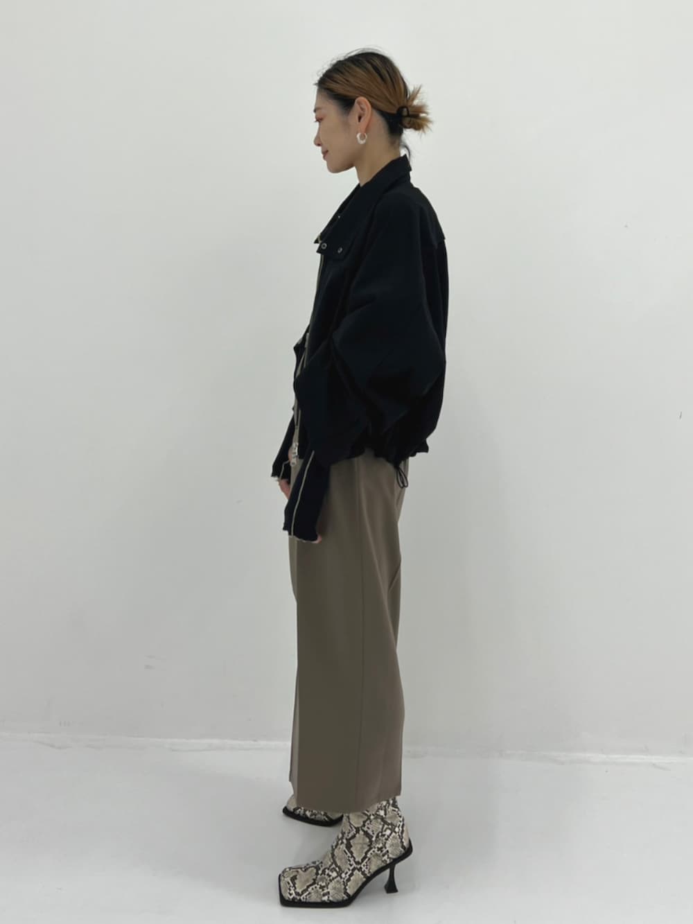 その他のブーツ、ブラック系のカーディガン/ボレロ、グレー系のスカートを着用したレディースの秋コーディネートの2枚目の写真