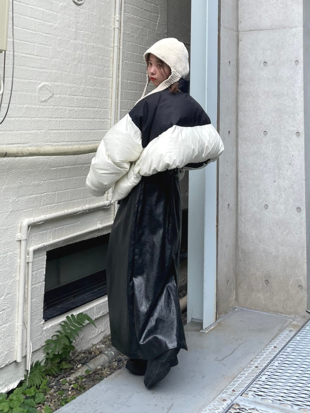 ブラック系のスカート、ホワイト系のダウンジャケット/コートを着用したレディースの秋コーディネートの2枚目の写真