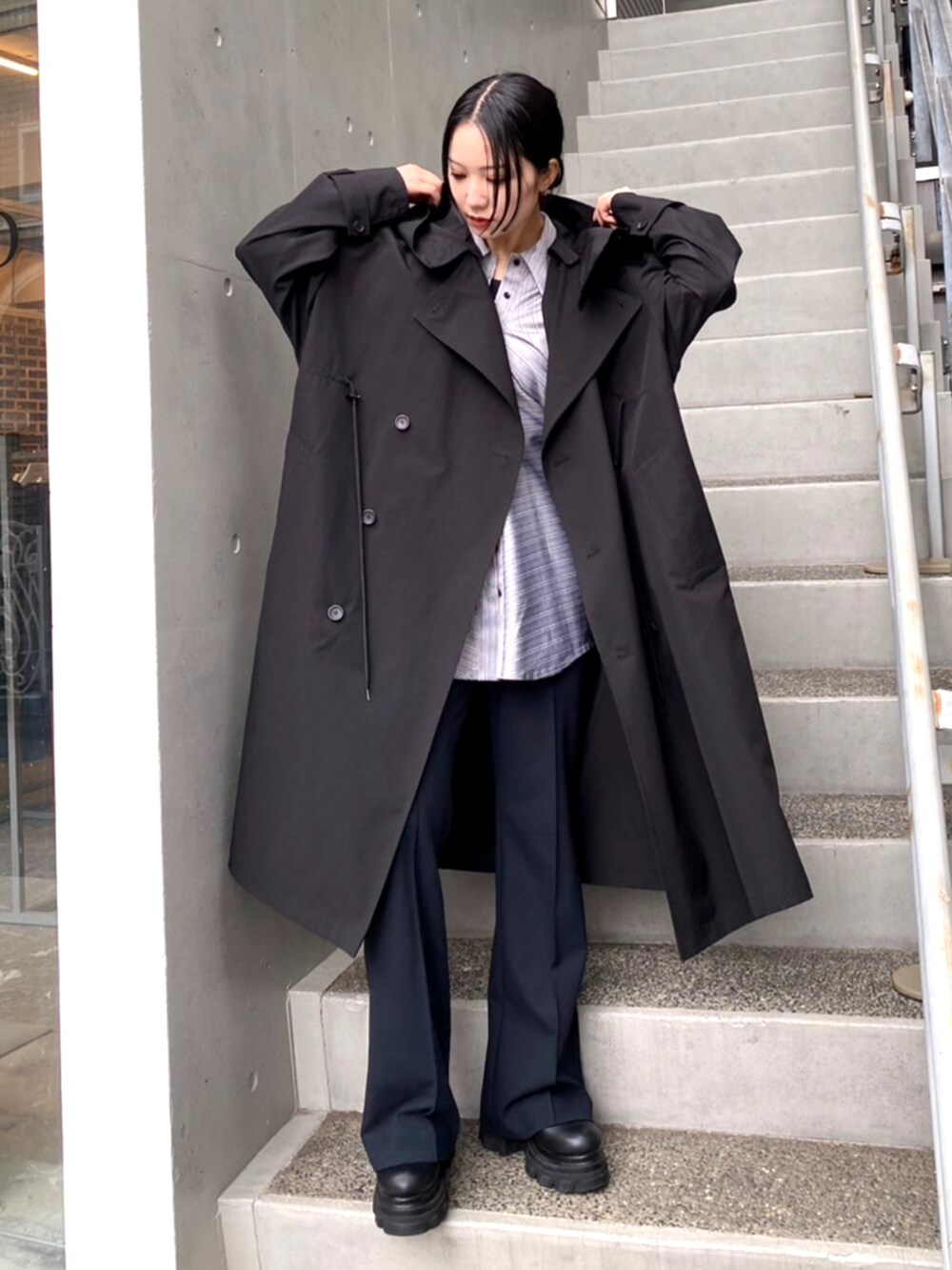 ブラック系のブーツ、ブラック系のトレンチコート、その他のシャツ/ブラウスを着用したレディースの秋コーディネートの2枚目の写真