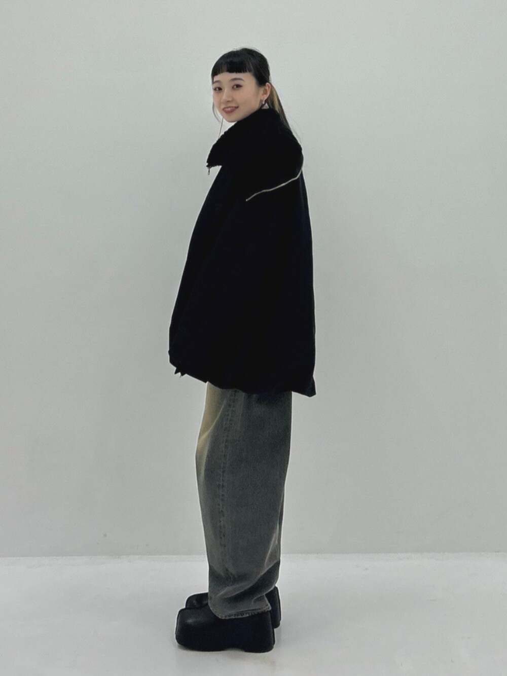 ブラック系のブルゾン、ブラック系のデニムパンツ、ブラック系のスリッポンを着用したレディースの秋コーディネートの2枚目の写真