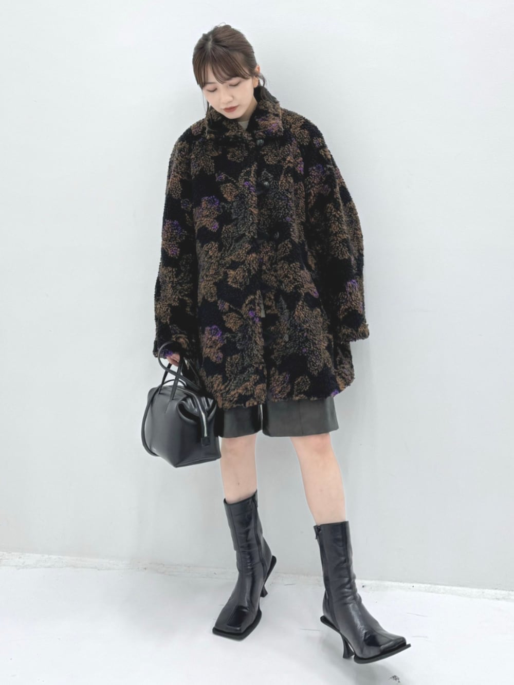 ブラック系のダッフルコート、ブラック系のハンドバッグを着用したレディースの秋コーディネートの2枚目の写真