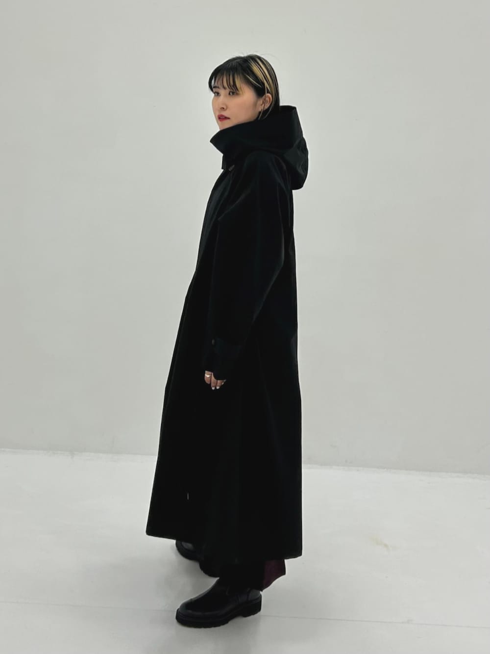 ブラック系のトレンチコートを着用したレディースの秋コーディネートの2枚目の写真