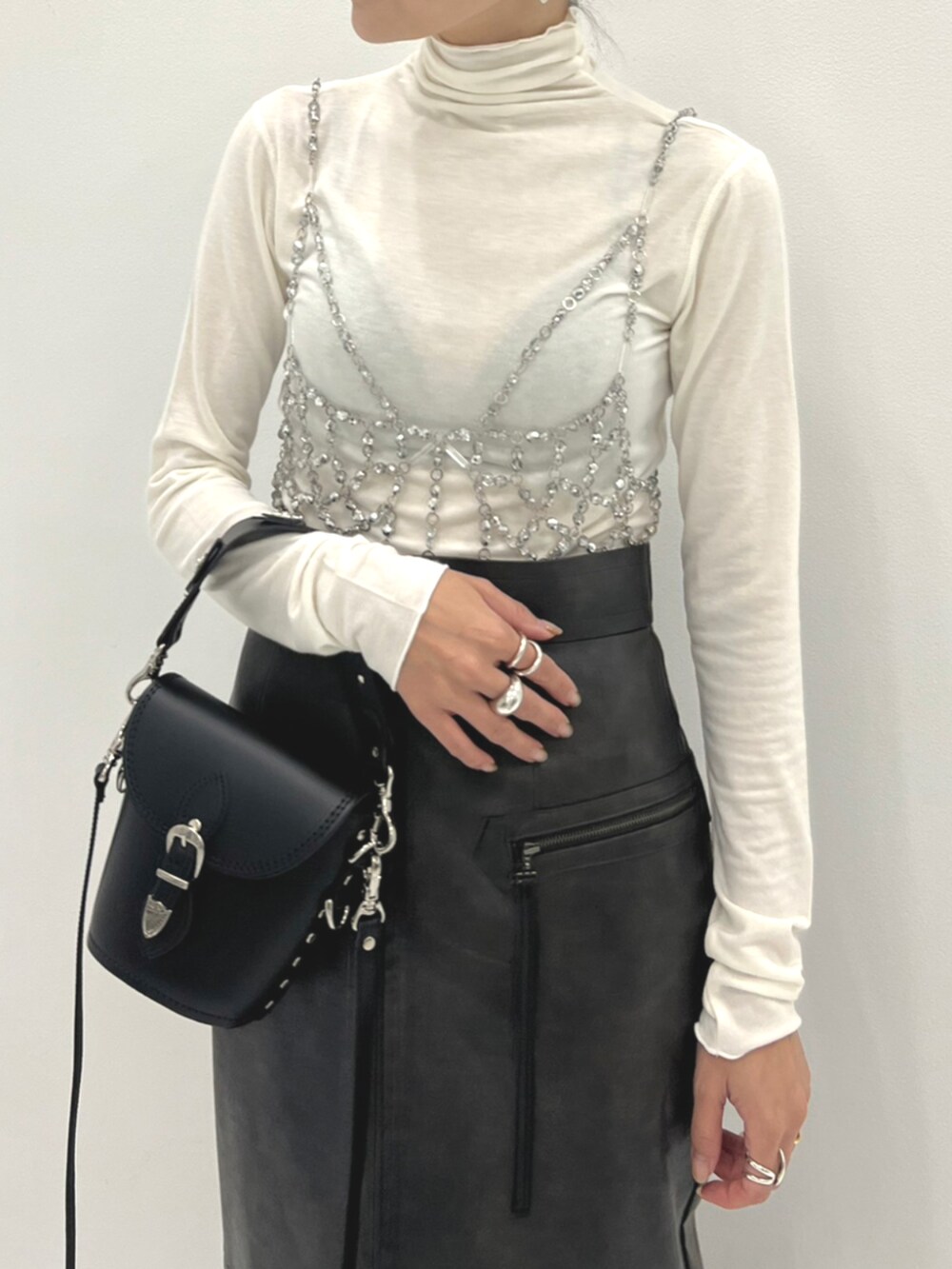ブラック系のブーツ、シルバー系のベスト、ホワイト系のTシャツ/カットソーを着用したレディースの秋コーディネートの3枚目の写真