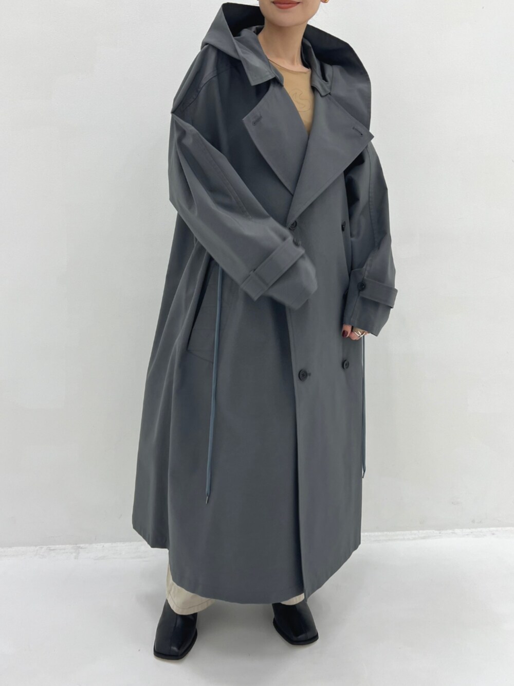 グレー系のトレンチコートを着用したレディースの秋コーディネートの4枚目の写真