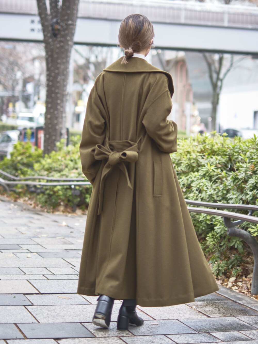 グリーン系のチェスターコートを着用したレディースの冬コーディネートの4枚目の写真