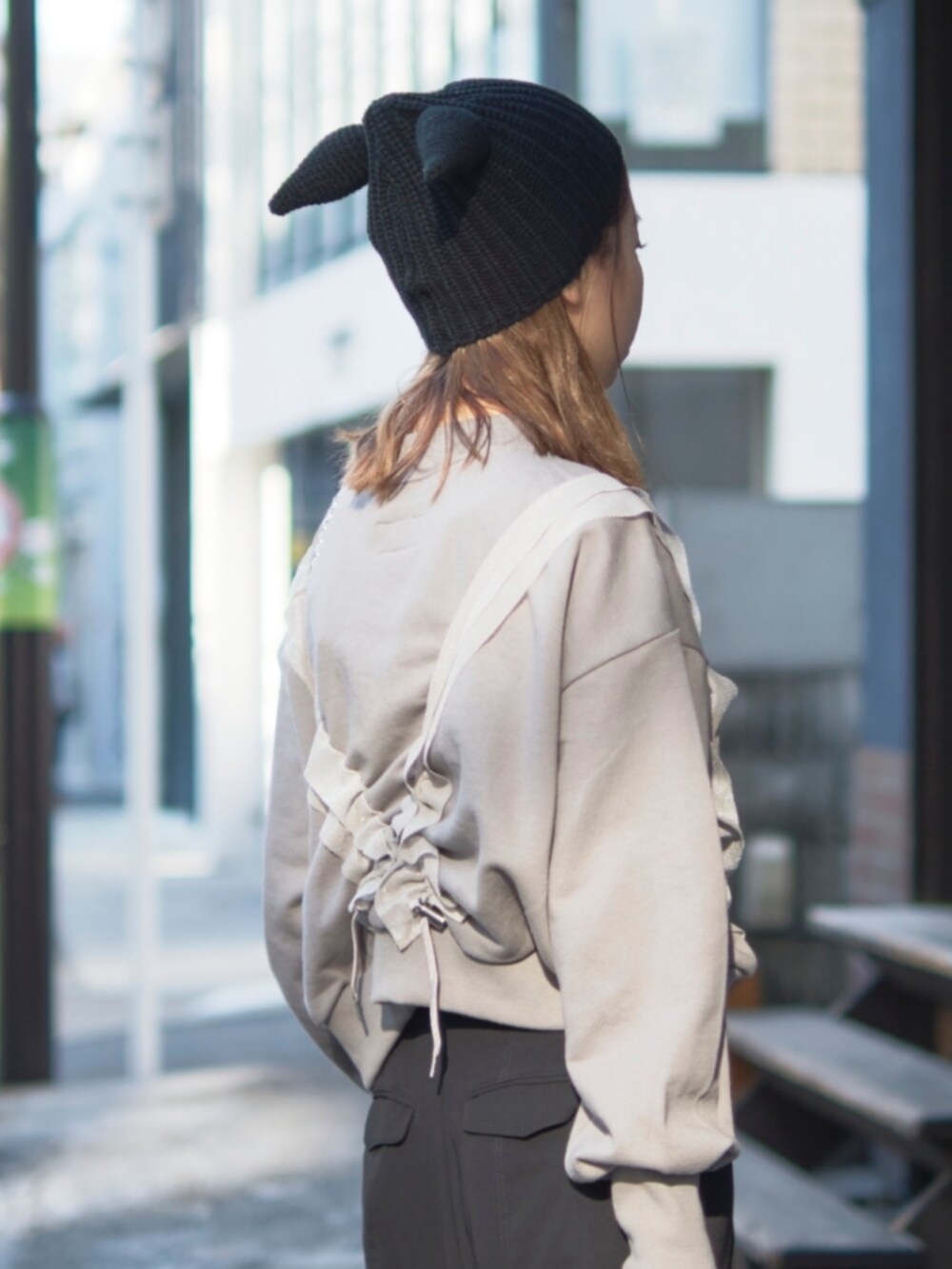 グレー系のスウェット、ブラック系のショルダーバッグ、ブラック系のニットキャップ/ビーニーを着用したレディースの冬コーディネートの4枚目の写真