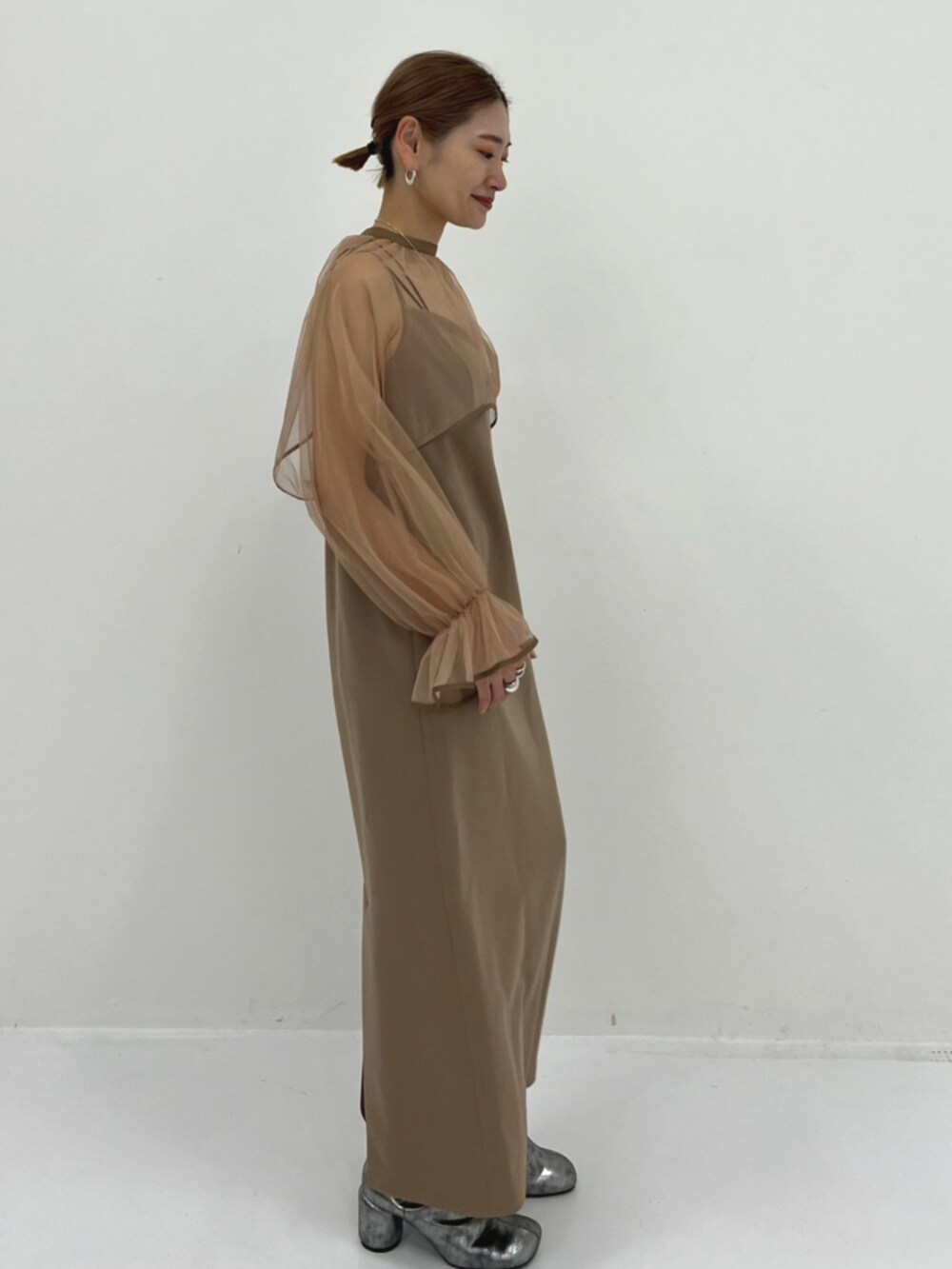 ベージュ系のワンピースを着用したレディースの秋コーディネートの2枚目の写真