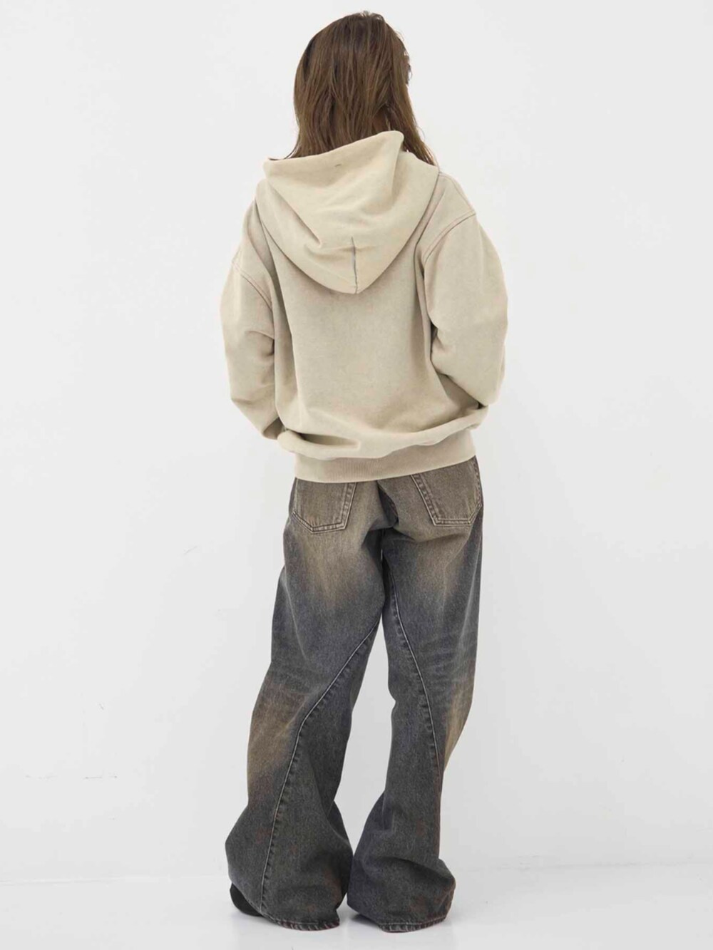 ベージュ系のパーカーを着用したレディースの冬コーディネートの3枚目の写真