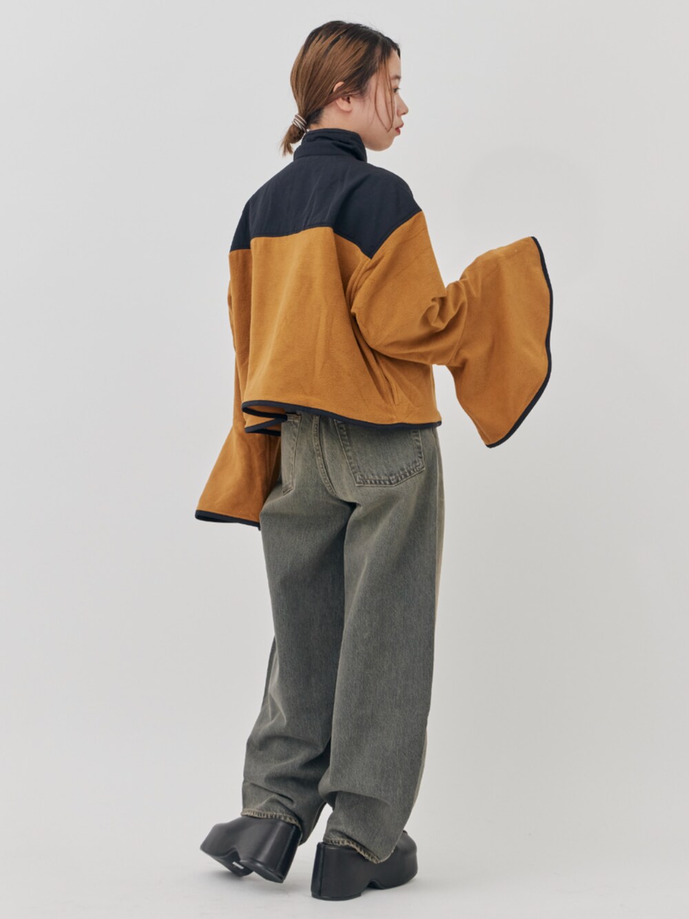 ブラック系のデニムパンツ、イエロー系のその他トップスを着用したレディースの秋コーディネートの3枚目の写真