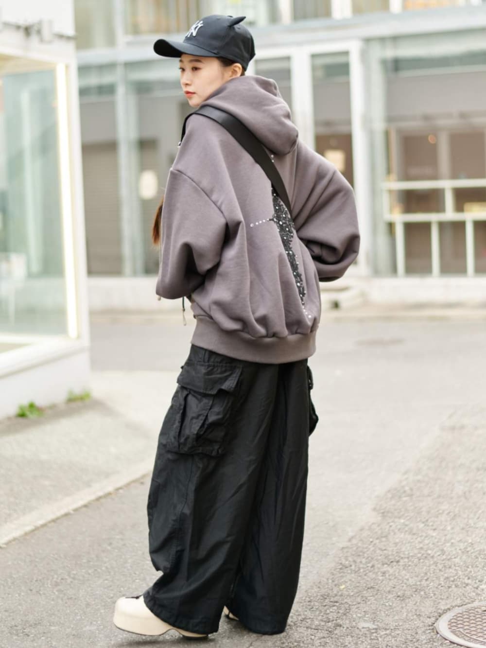 ベージュ系のスリッポン、グレー系のパーカー、ブラック系のキャップを着用したレディースの冬コーディネートの3枚目の写真