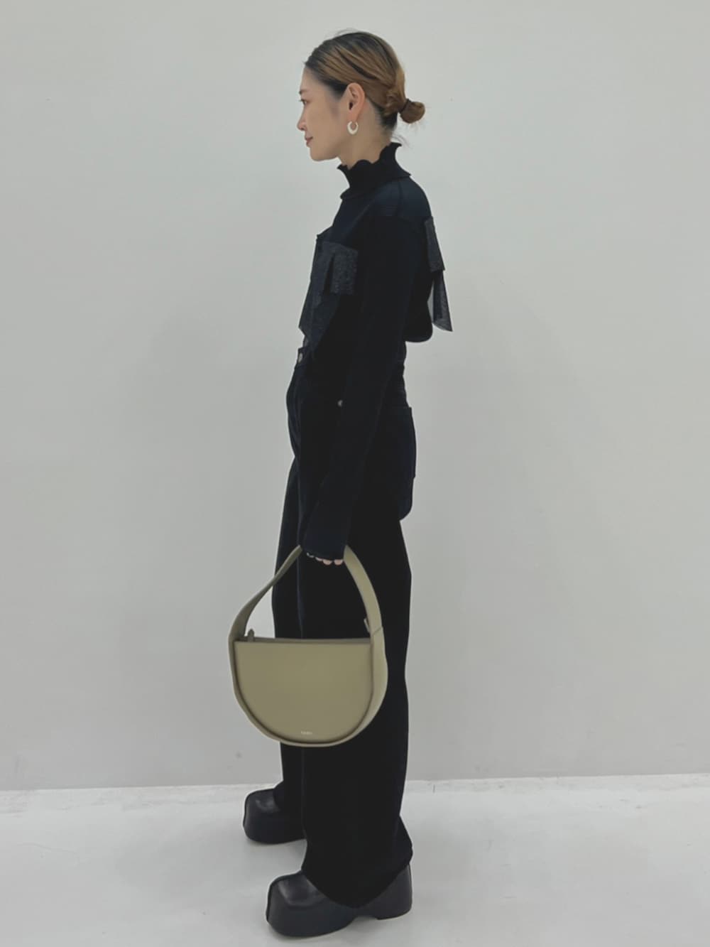 ブラック系のTシャツ/カットソー、ブラック系のデニムパンツ、グレー系のハンドバッグを着用したレディースの秋コーディネートの2枚目の写真